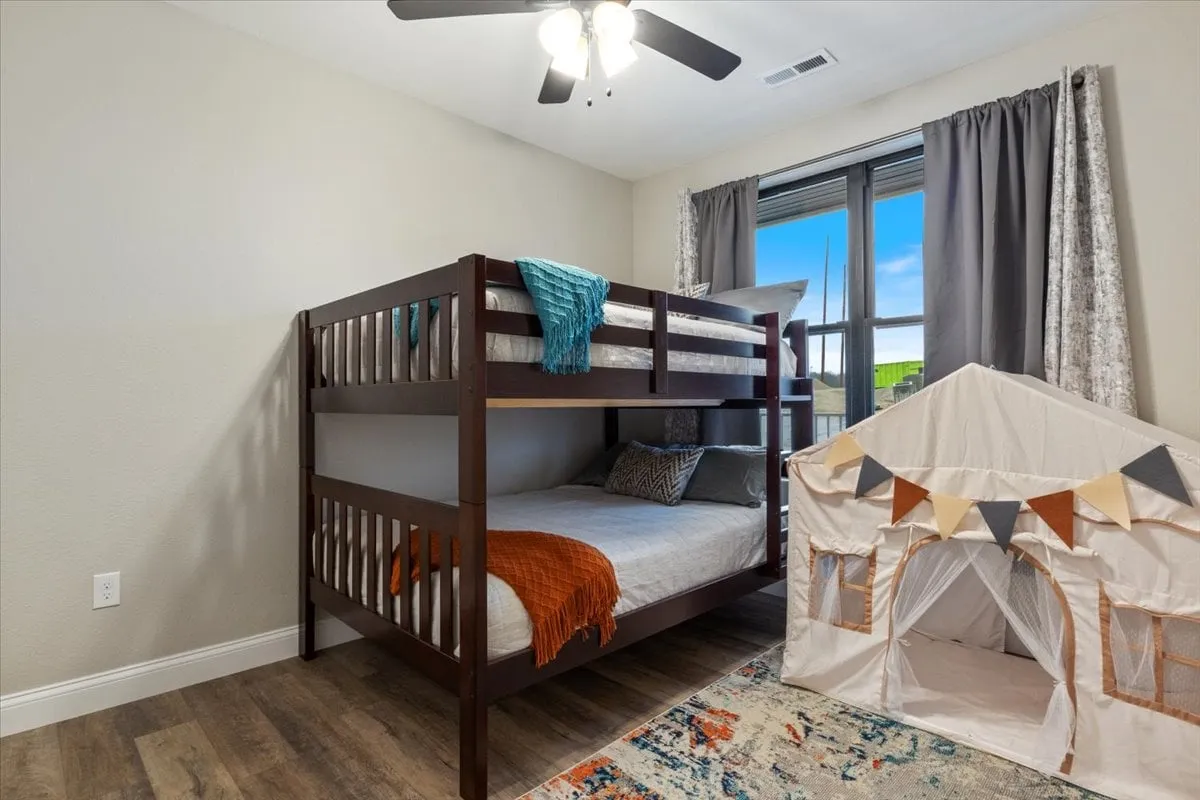 This image features a whimsical kids’ area with a sturdy bunk bed, playful tent, and a soft rug, creating a perfect environment for imaginative play, reading, and restful nights. The space is colorful and inviting, evoking a sense of adventure and comfort especially for young children.