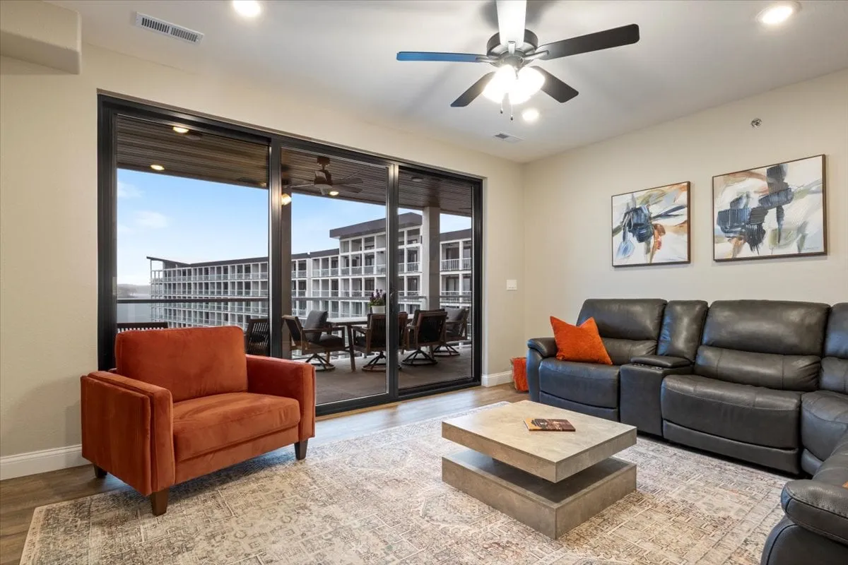 A comfortable living area with large sliding glass doors, plush seating, a modern coffee table, and curated wall art. Natural light floods the space, creating a relaxing environment ideal for socializing or unwinding.